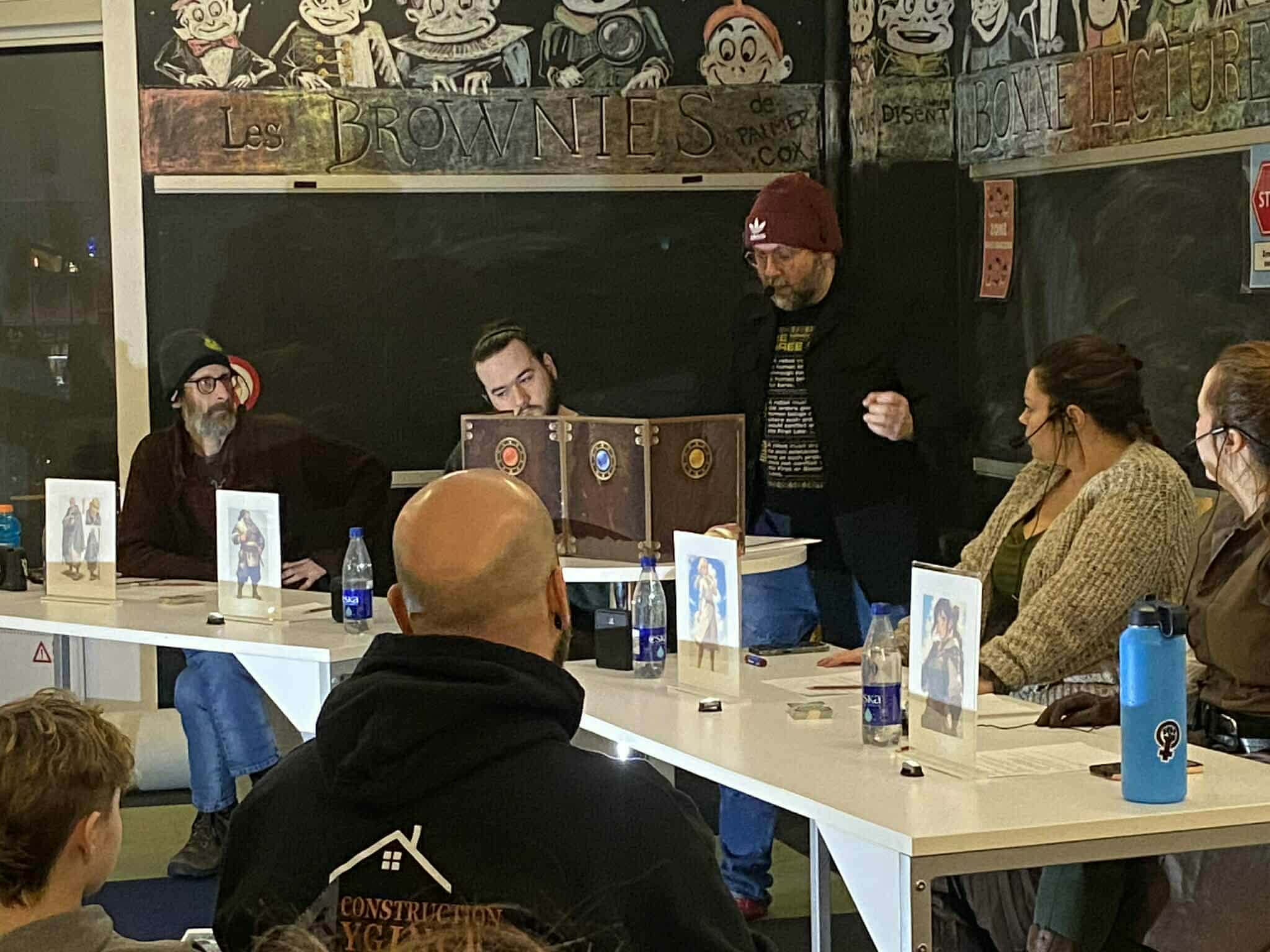 Groupe de personnes réunies autour d’une grande table pour une séance de jeux de rôles.