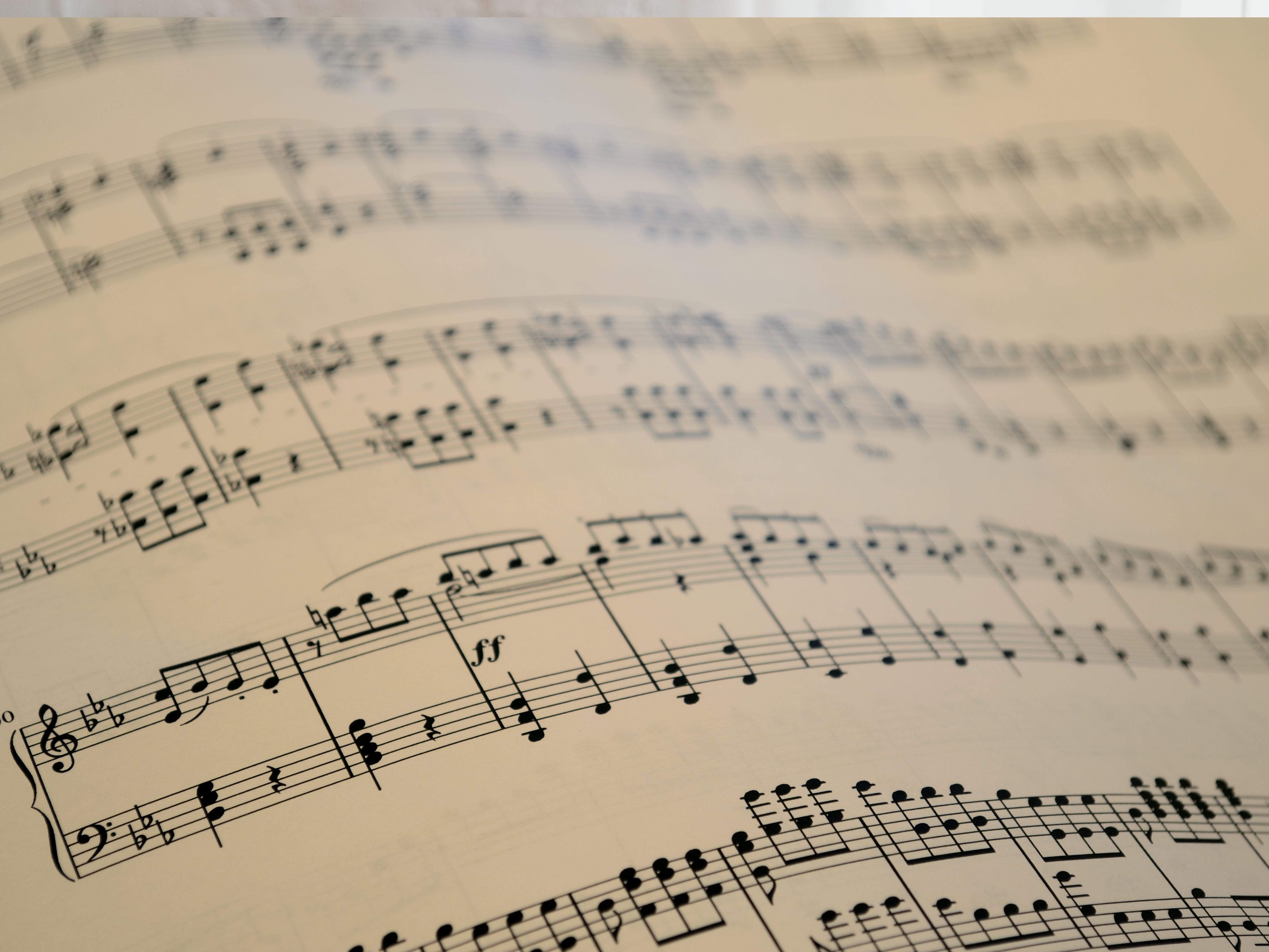 quebec-musique-125-ans.jpg Partition musicale en gros plan avec des portées et des notes imprimées.