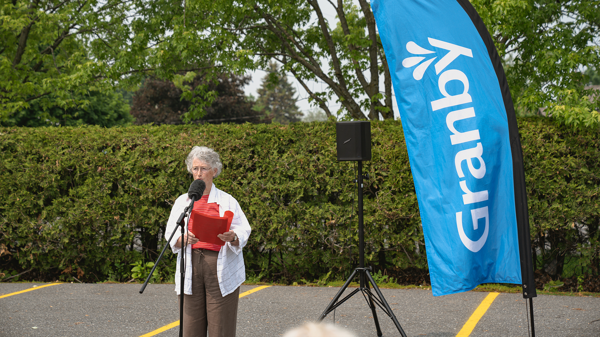 Une dame debout devant un micro, lors de l’inauguration d’un espace dédié à David Bouchard, maire du canton de Granby de 1937 à 1963.